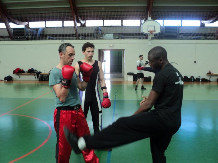 Modibo Diarra démontre un coup de pied lors d'un stage de boxe en gymnase